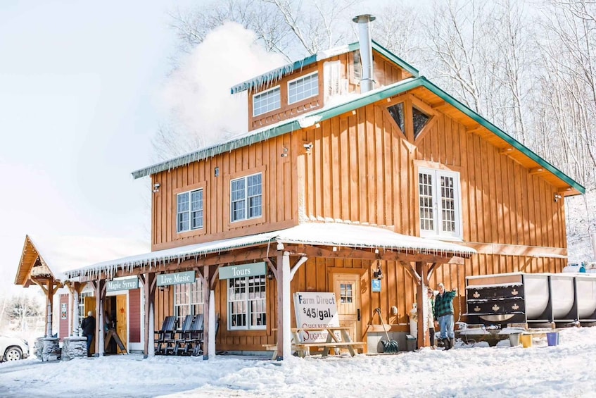 A wooden building with a green roof, surrounded by snow. 3