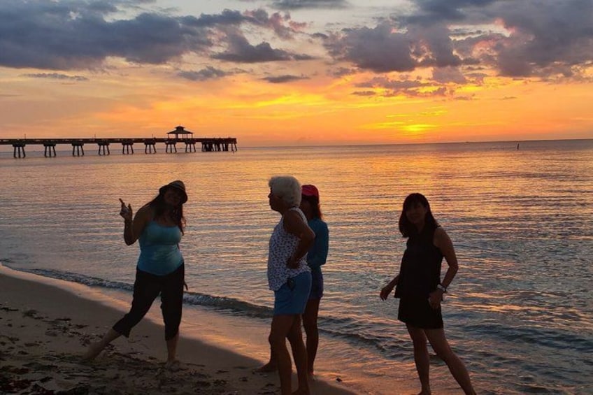 A sunset over a beach with a pier in the background. 3