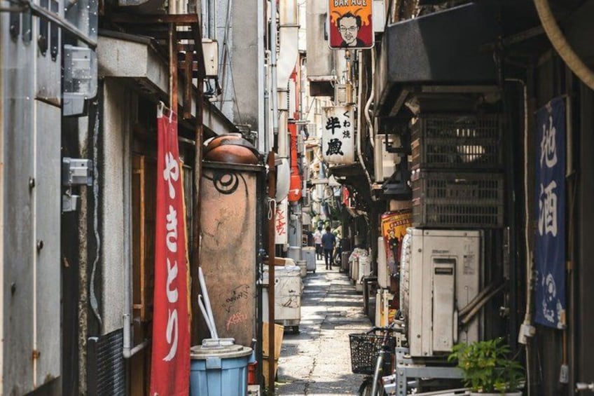 A narrow alleyway with various signs and buildings. 3