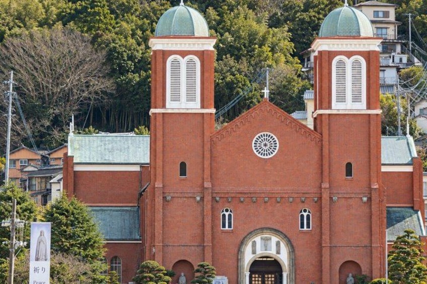 A red brick church with two domes and a circular window. 5