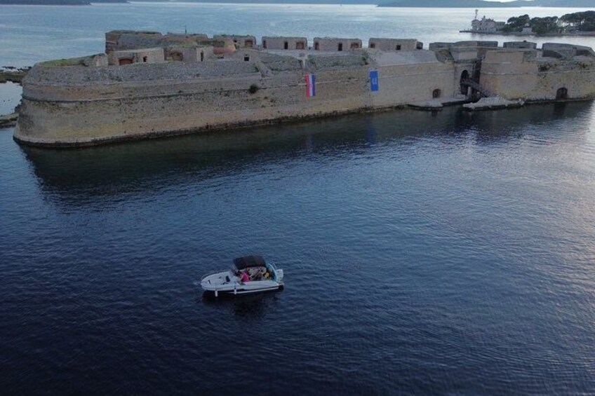 A fortified island with a boat in the water. 3