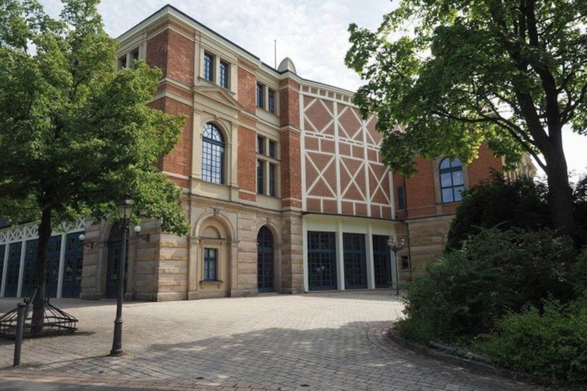 A historic building with a symmetrical facade, large windows, and a central entrance. 2