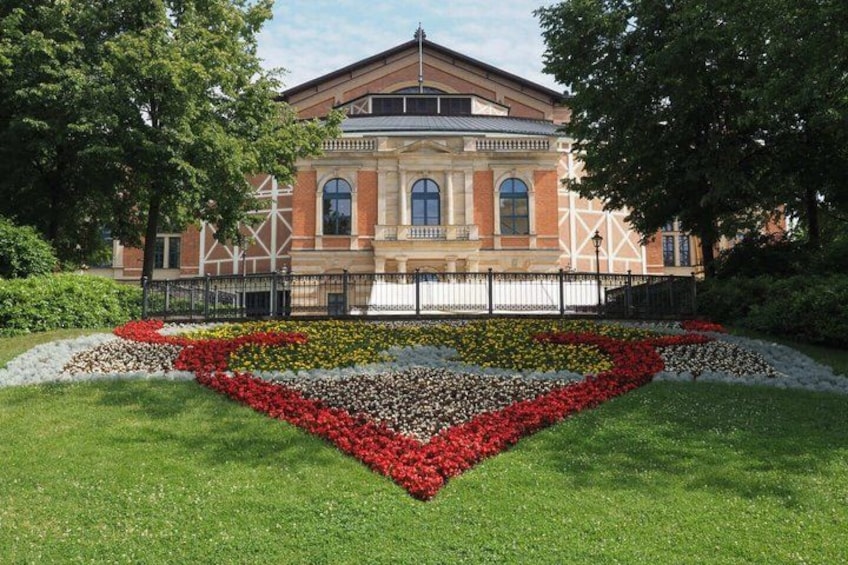 A building with a symmetrical facade, surrounded by a landscaped garden with a heart-shaped flower bed. 4