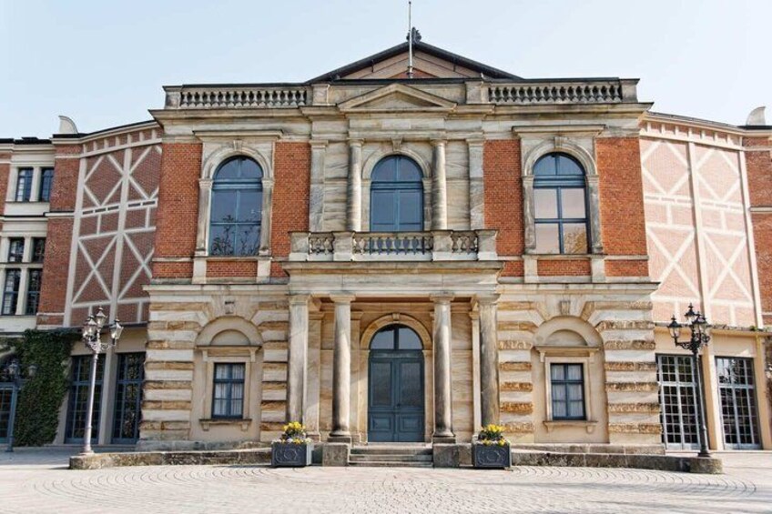 A historic building with a symmetrical facade, large windows, and a central entrance. 3
