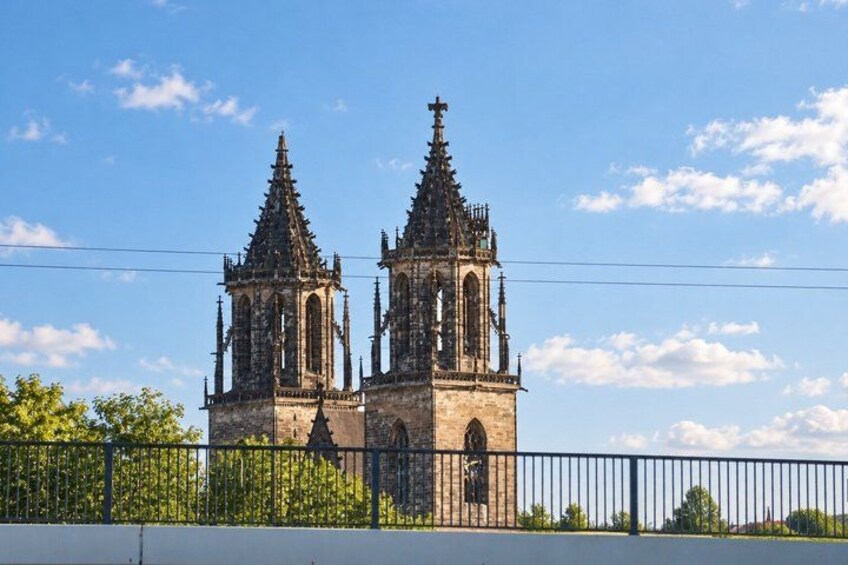 A Gothic-style church with two towers and a fence in the foreground. 4