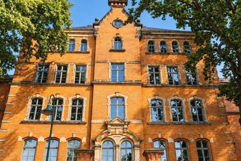 A large brick building with multiple windows and a central entrance. 2