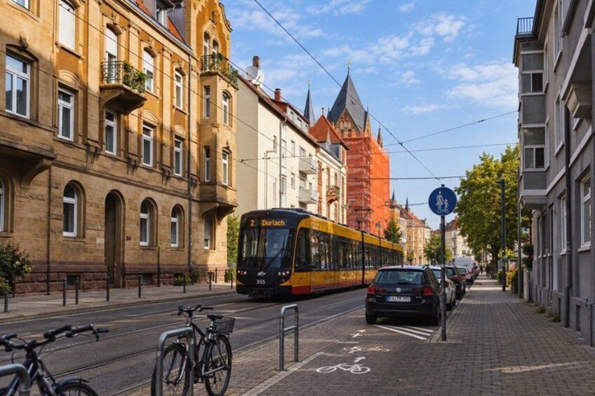A tram on a city street, buildings, and a bicycle. 5