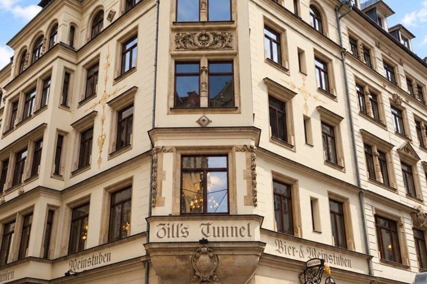 A historic building with ornate architectural details, including a prominent sign reading 'Jill's Tunnel.' 5