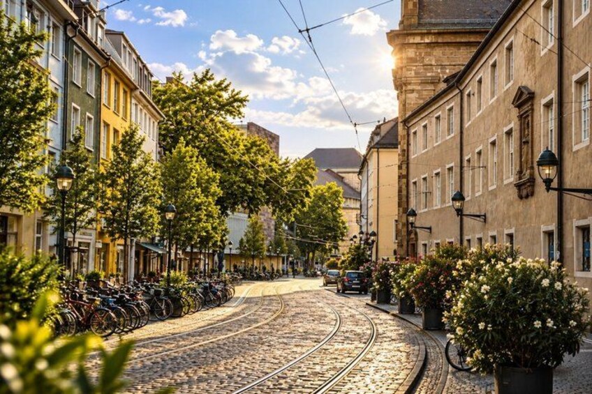 A cobblestone street with tram tracks, bicycles, and buildings with balconies. 3