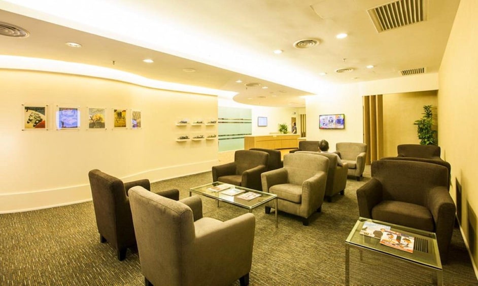 A modern waiting area with comfortable seating, a reception desk, and artwork on the walls. 1