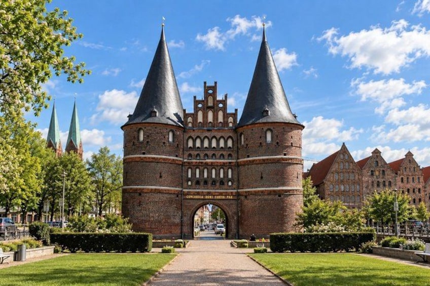 A historic brick building with two prominent towers and a central archway. 2
