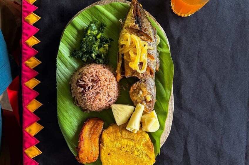 A meal on a banana leaf with rice, fish, vegetables, and a drink. 3