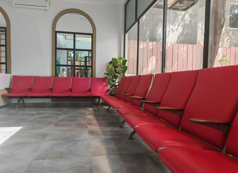 A waiting area with red chairs and a large window. 5