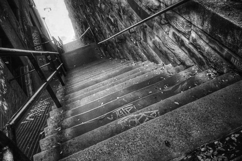 A set of stone steps with metal railings, leading up a flight of stairs. 4