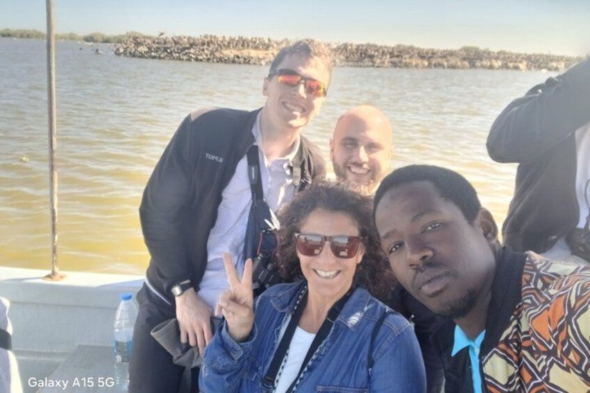 A group of people on a boat with a body of water and a shoreline in the background. 3