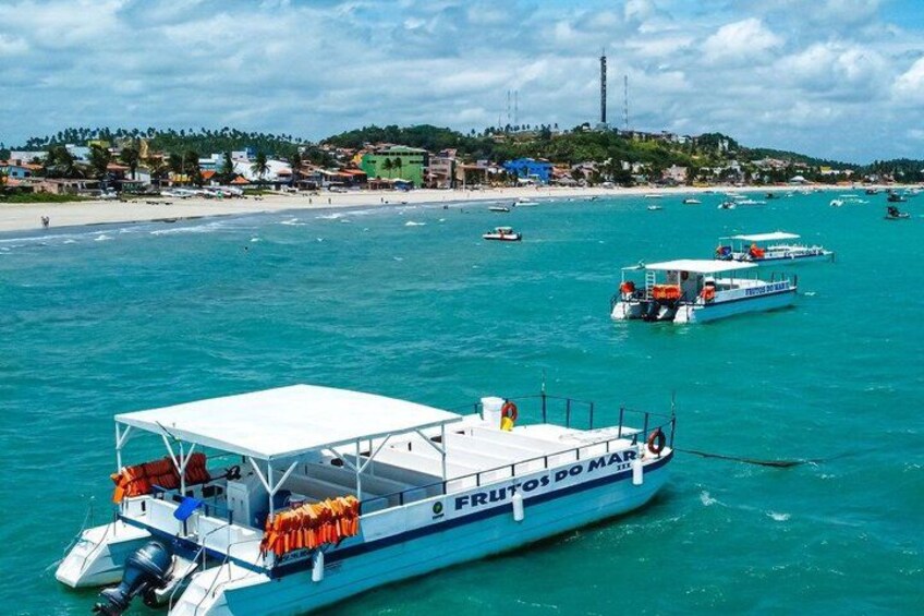 A coastal scene with a boat named 'FRUTOS DO MAR' and several other boats in the turquoise sea. 5
