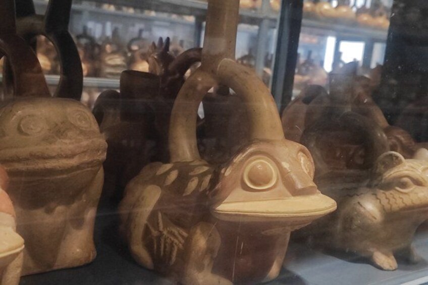 A display of ceramic frog figurines in a store window. 5