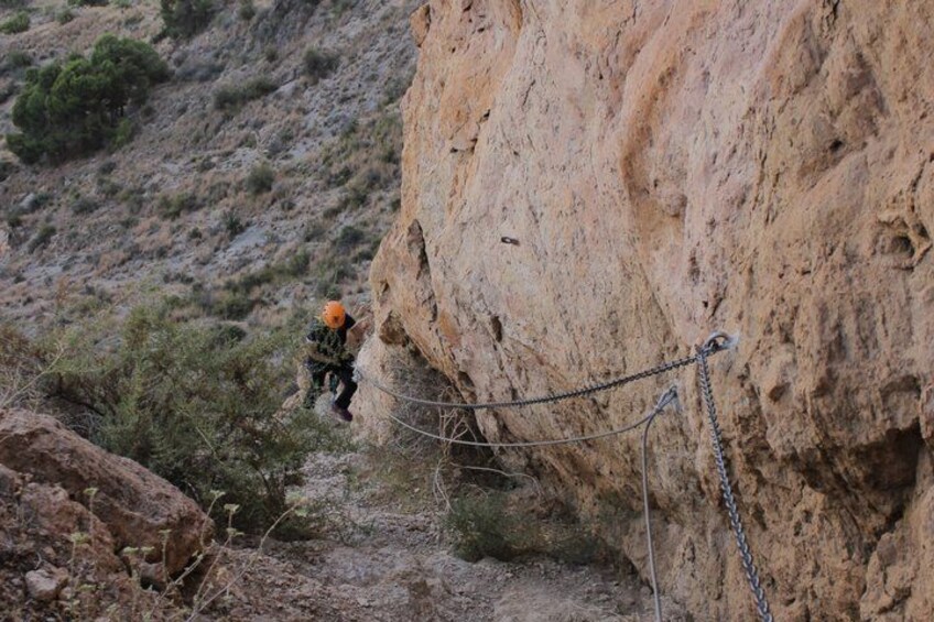 A person rappelling down a rocky cliff. 3