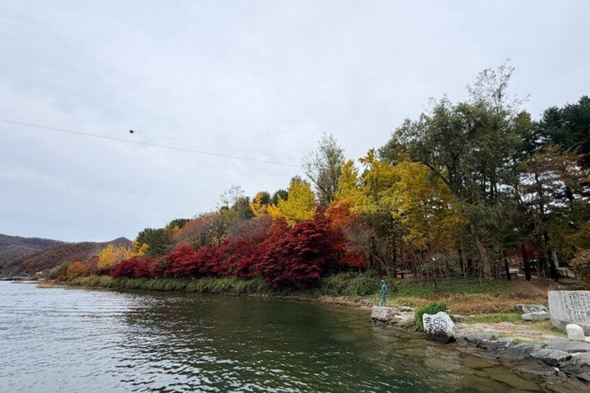 A river with autumn foliage, a rocky shoreline, and distant hills. 5