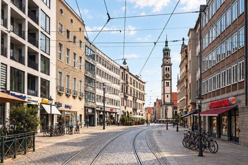 A tram line, buildings, and a clock tower. 5