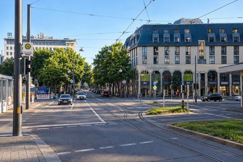 A tram line, a tram stop, and a building with a blue roof. 4