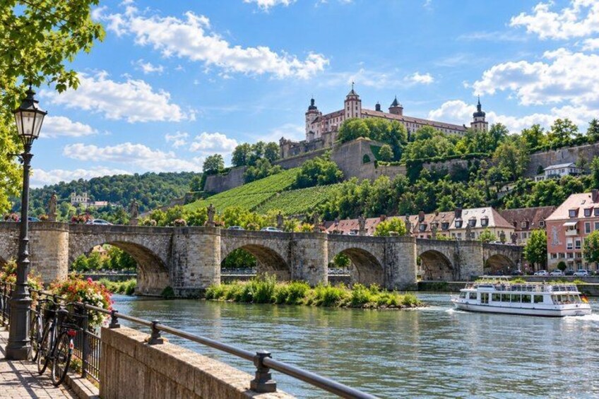 A river with a bridge, a boat, and a castle on a hill. 5