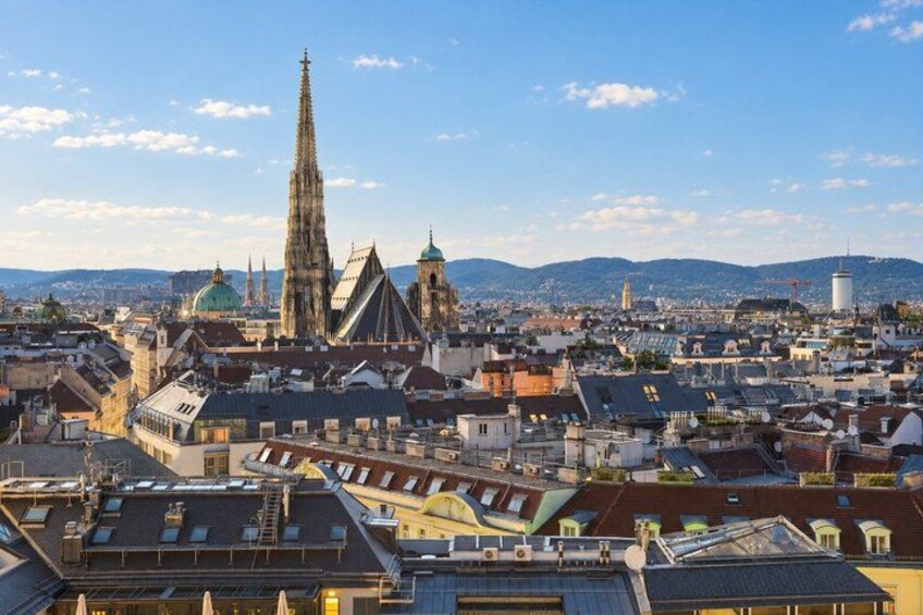 A cityscape with prominent Gothic architecture, including a tall spire and a cathedral with a green dome. 2