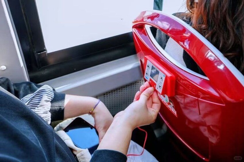 A person using a red public weighing scale. 5
