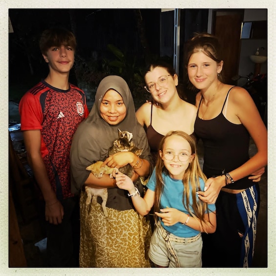 A group of people indoors, some holding a kitten. 2