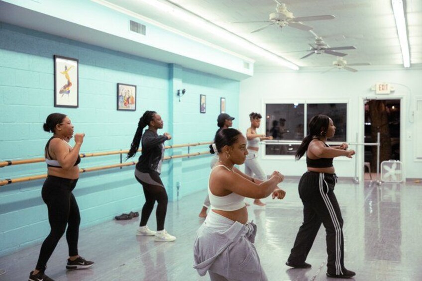 A dance studio with ballet barres along the wall, a ceiling fan, and a door marked 'EXIT'. 2