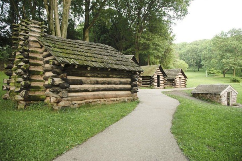 A log cabin trail with a gravel path leading through a wooded area. 3