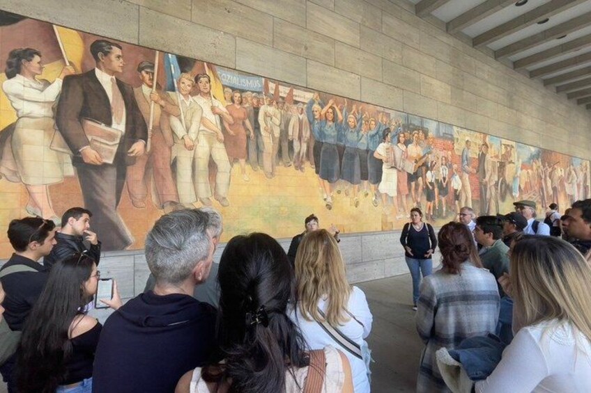 A mural with people and a crowd of onlookers. 4
