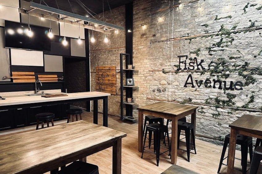 A modern interior with exposed brick walls, wooden tables, and a sign reading 'Fisk Avenue'. 3