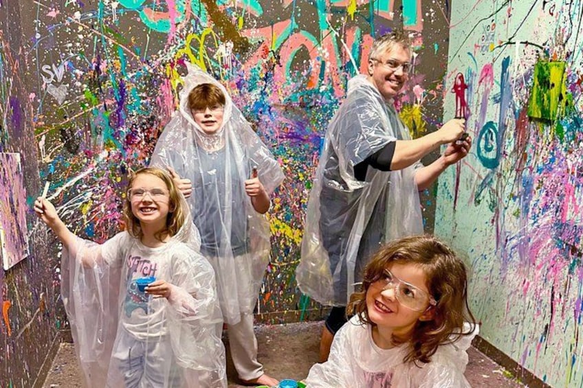 A group of people in a room with colorful graffiti on the walls. 1