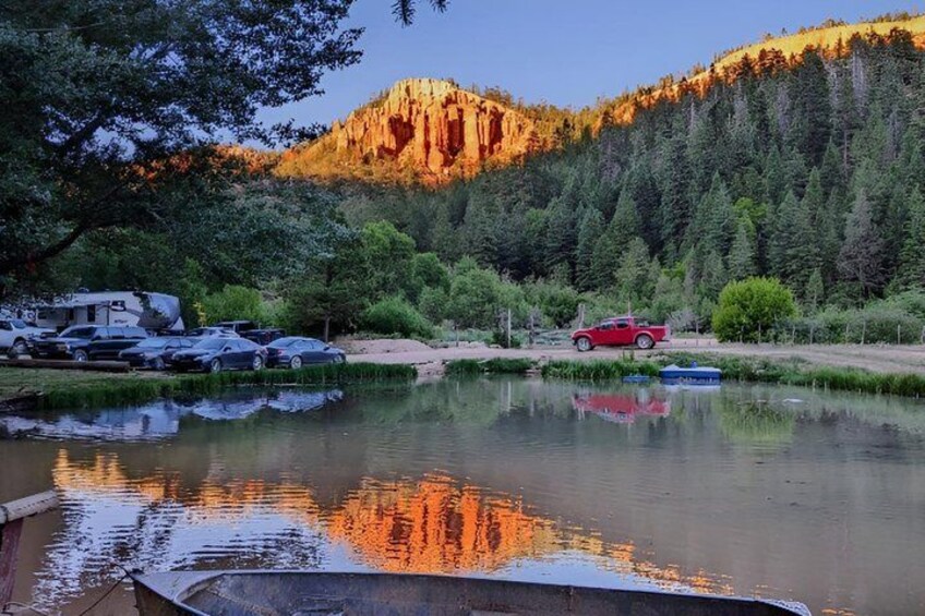 A lake with reflections, a red truck, and a mountain in the background. 2