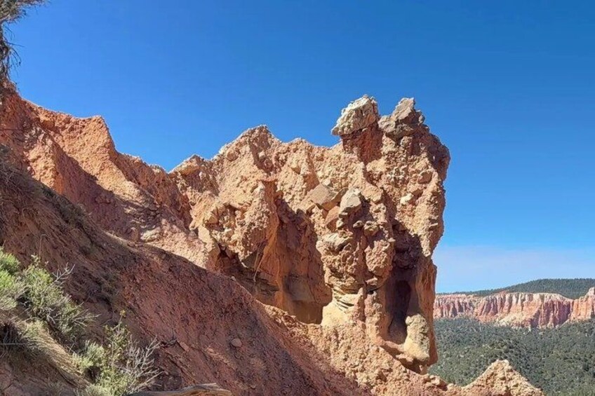 A rugged rock formation with a clear blue sky. 1
