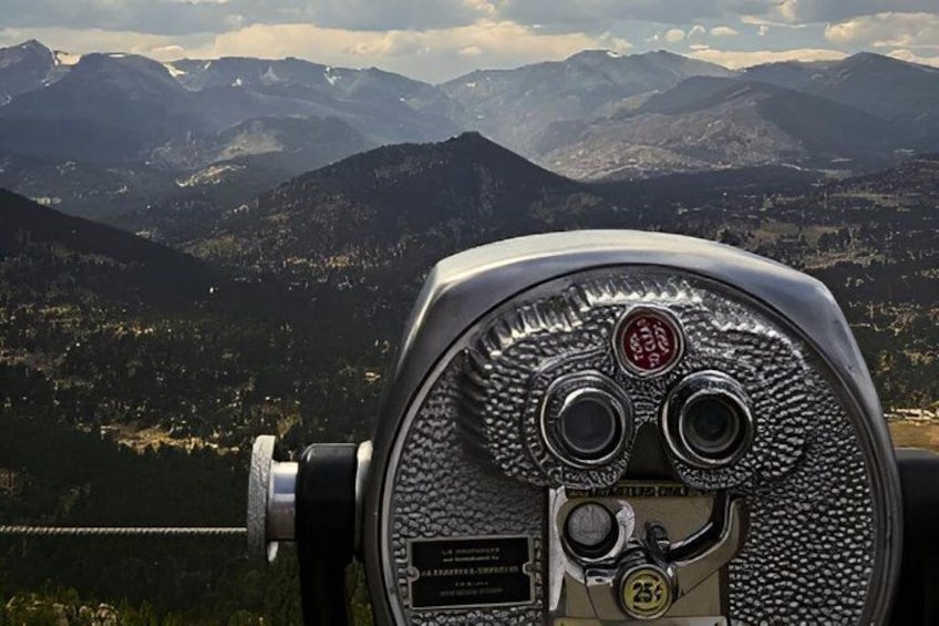 A telescope with a view of a mountainous landscape. 5