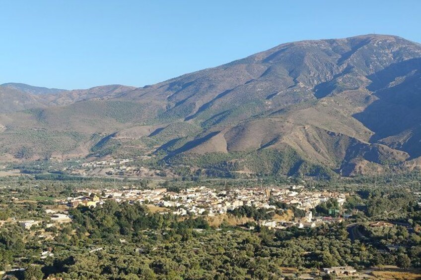 A town nestled in a valley with a mountain in the background. 2