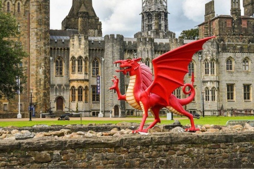 A red dragon statue in front of a historic building with stone architecture. 3