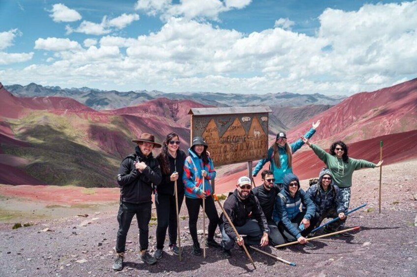 A group of people on a mountain with a sign in the background. 3