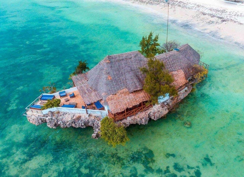 Luchtbeeld van een afgelegen eiland met rieten hutten en een heldere blauwe zee. 4