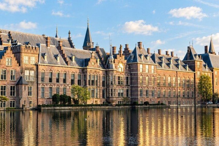 A historic building with multiple gabled roofs and a large body of water in the foreground. 4