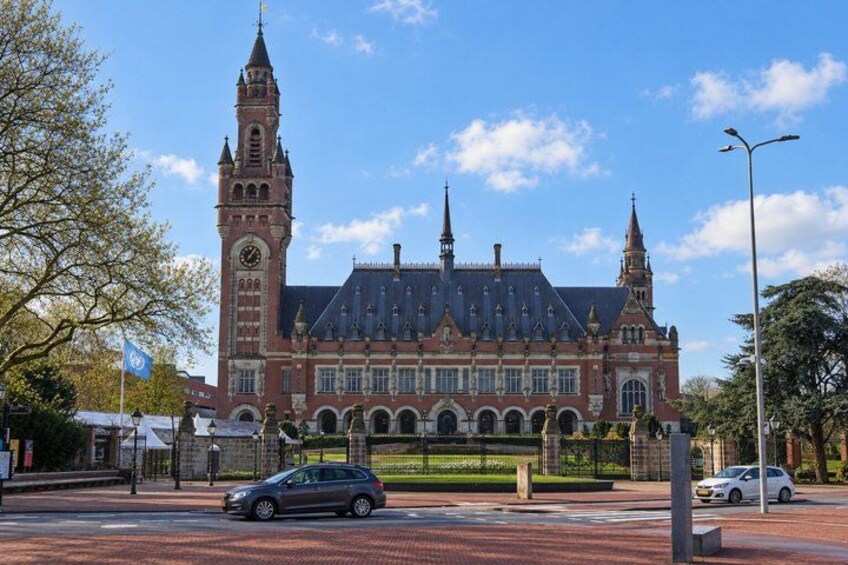 A historic building with a clock tower, arched windows, and a large central entrance. 2