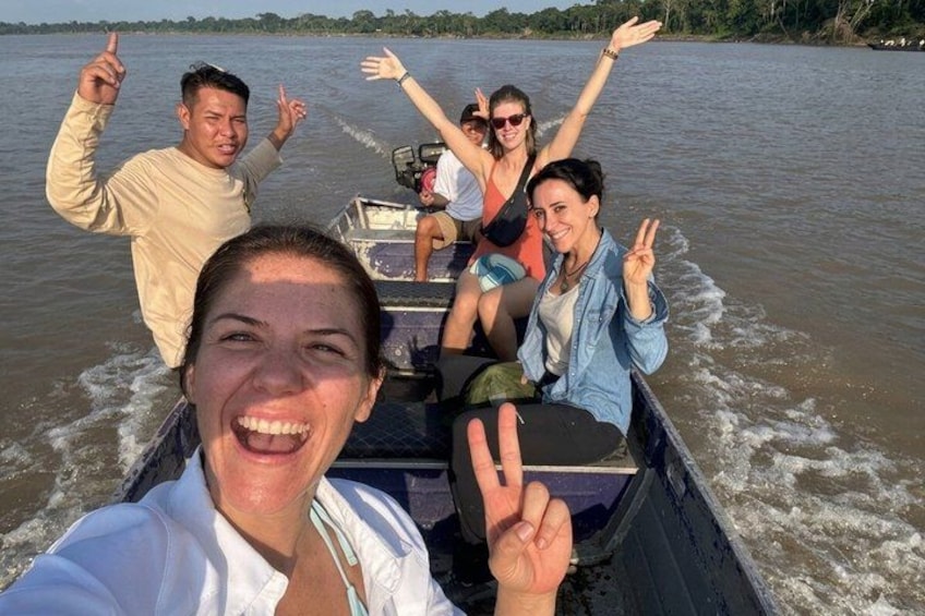 A group of people on a boat with water splashing around them. 5