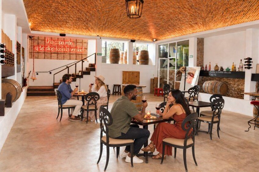 A restaurant with wooden ceilings, tables, chairs, and wine barrels. 5