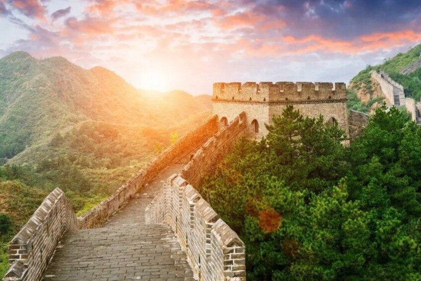 The Great Wall of China, a historic fortification, with a mountainous backdrop and a clear sky. 5