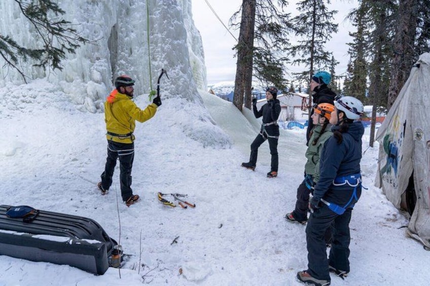 A group of people in a snowy outdoor setting with a tent and a sled. 2
