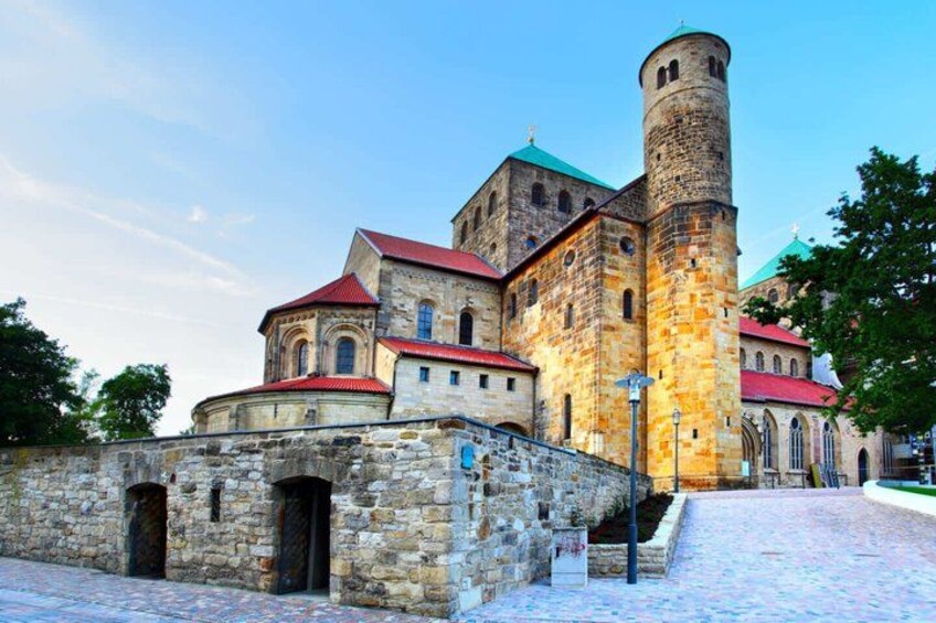 A historic stone building with a red roof and a tall tower. 4