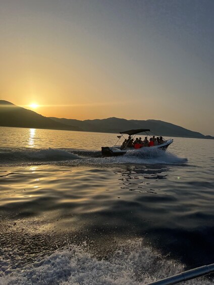 A boat with passengers on a calm lake at sunset. 4
