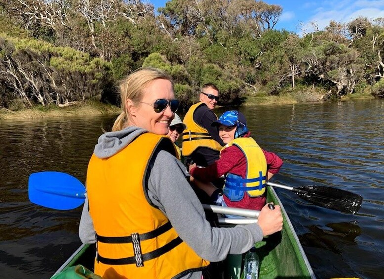 People in a canoe on a river surrounded by trees. 3